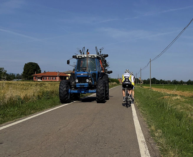 un tracteur et des vélos se croisent sur une route de campagne - Illustration Cyclistes et engins agricoles  Partager la route en toute sécurité 