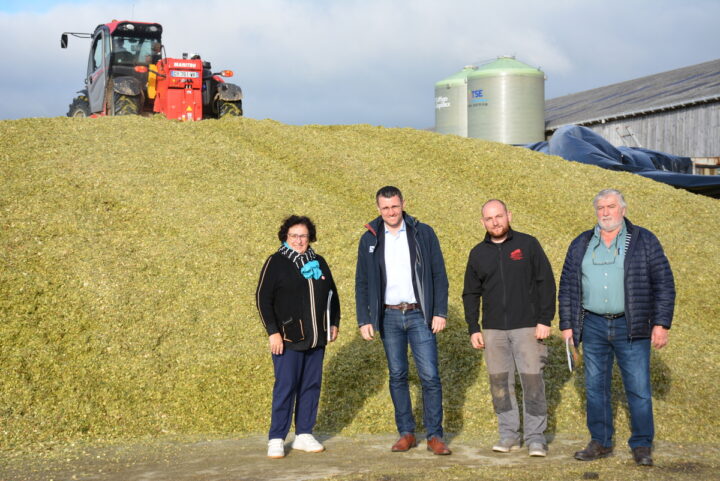 Quatre personnes devant un tas de maïs