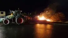 Feu de colère dans la nuit avec un tracteur à côté