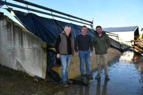 Les trois hommes devant le silo de maïs
