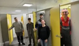 Quatre hommes et une femme présentent les nouveaux vestaires d'un élevage de porc.