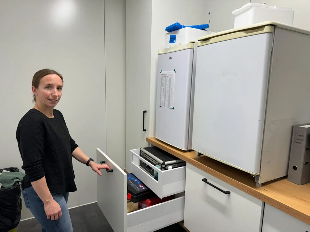 Une éleveuse dans une pièce de stockage équipée de tiroir et d'une frigidaire.