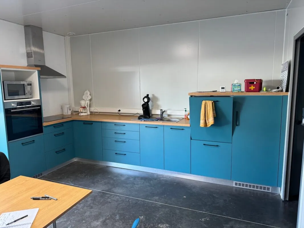 Un espace cuisine tout équipé de couleur bleue.