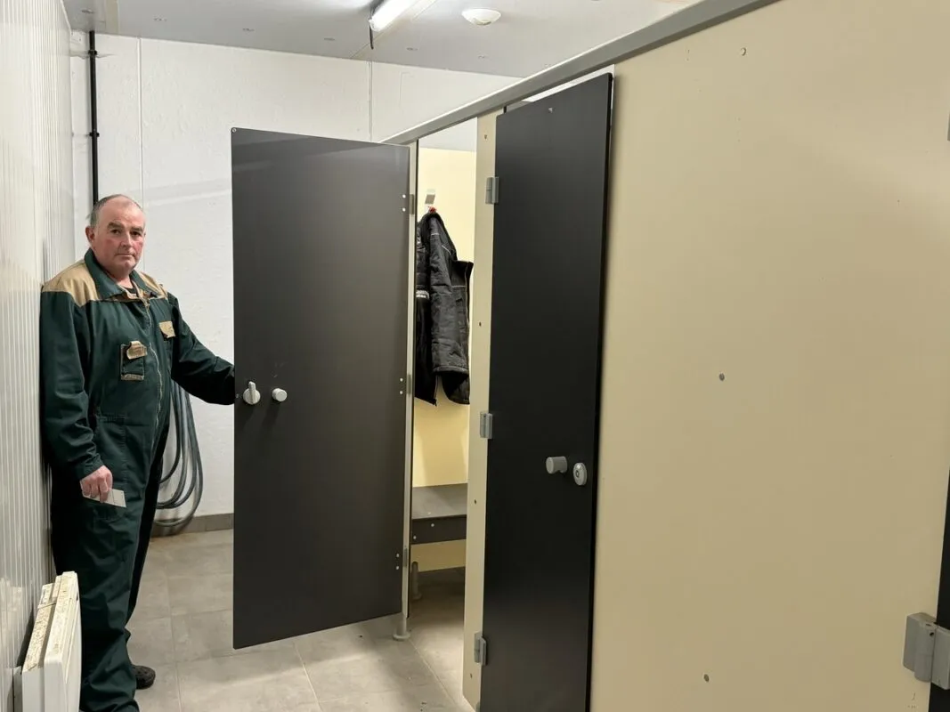 Un salarié agricole ouvre la porte de son vestiaire.