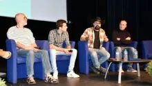 Les quatre intervenants en table ronde dans la salle de conférence
