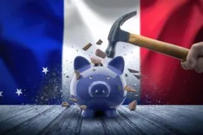 Une tirelire qui se casse sous le poids d'un marteau avec en fond le drapeau français