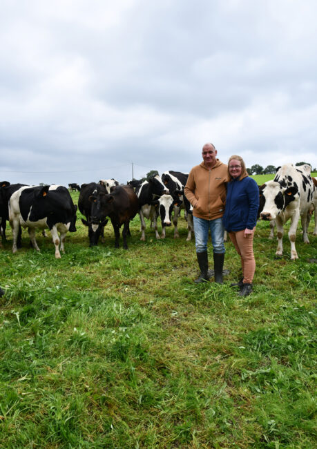 Les éleveurs devant les vaches laitières au pâturage.