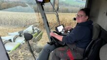 Une jeune femme au volant dans une cabine de moissonneuse