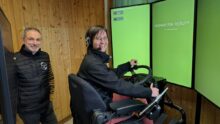 UN homme et une femme devant les écrans d'un simulateur de conduite de tracteur