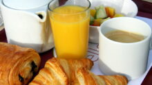 PETIT DÉJEUNER AVEC CAFÉ, JUS D'ORANGE ET PAIN AU CHOCOLAT