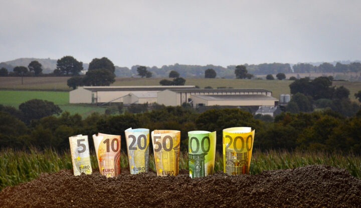 montage de billets devant un bâtiment agricole