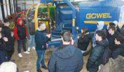 Des élèves devant une presse/enrubanneuse