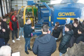 Des élèves devant une presse/enrubanneuse