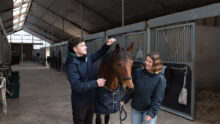 Un étudiant et une étudiante avec un cheval.