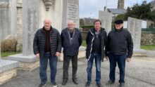 Des hommes devant le monument aux morts de Plouider