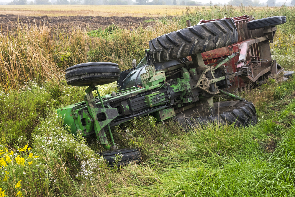 Un tracteur retourné dans une prairie - Illustration Renversement de tracteur : comment l’éviter ?
