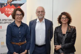 2 femmes et 1 hommes devant l'affiche "Faire 2030" du Crédit Mutuel Arkéa