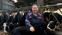 Anne-Cécile Zuurbier, avec son chien dans la stabulation des vaches