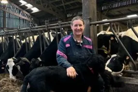 Anne-Cécile Zuurbier, avec son chien dans la stabulation des vaches