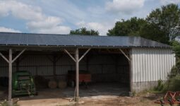 Un hangar de stockage de matériel agricole avec des panneaux photovoltaïques en toiture