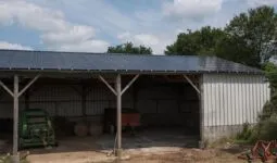 Un hangar de stockage de matériel agricole avec des panneaux photovoltaïques en toiture