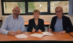 Trois personnes signent un partenariat
