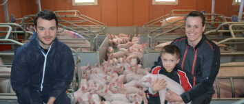 Un couple et leur fils dans une maternité porcine au milieu des truies et des porcelets