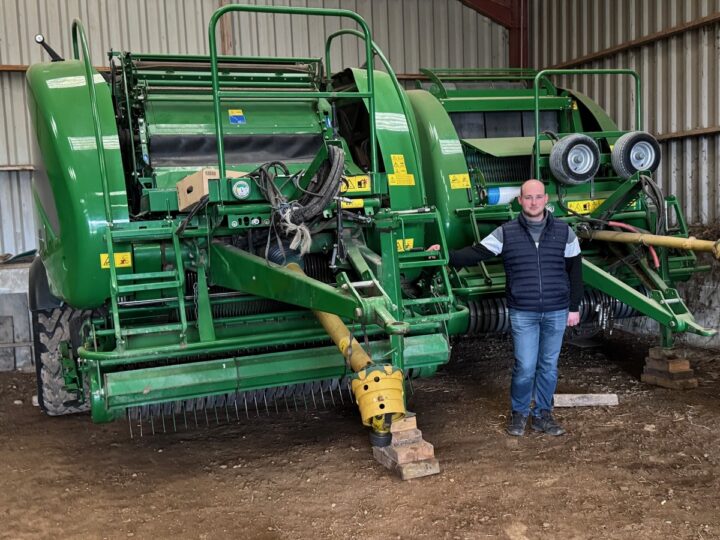 Un éleveur devant deux outils pour presser de l'herbe.