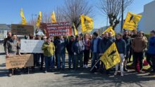 Un groupe de personnes avec des drapeaux jaunes du syndicat Confédération Paysanne
