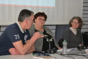 Trois personnes à une tribune