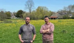 Deux hommes devant une prairie contenant des fleurs jaunes
