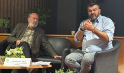 Deux hommes assis lors d'une table ronde.