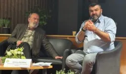 Deux hommes assis lors d'une table ronde.