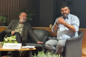 Deux hommes assis lors d'une table ronde.