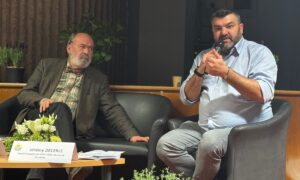Deux hommes assis lors d'une table ronde.
