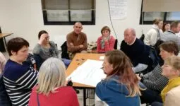 groupe de personnes en réunion autour d'une table
