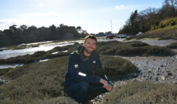 Ewen Frin en train de récolter des herbes marines sur une plage