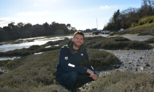 Ewen Frin en train de récolter des herbes marines sur une plage