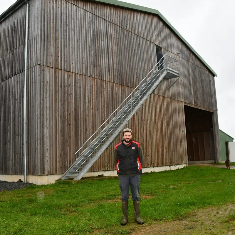 Le bâtiment est bardé de bois avec un escalier - Illustration Du séchage en grange « thermovoltaïque »