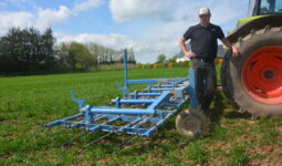 Un agriculteur devant sa herse étrille
