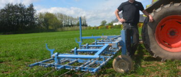 Un agriculteur devant sa herse étrille