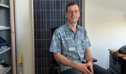 Un homme assis devant un panneau solaire