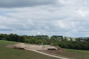 Un chantier de terrassement de bâtiment agricole au milieu de champs de maïs