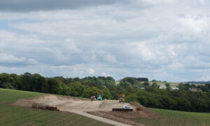 Un chantier de terrassement de bâtiment agricole au milieu de champs de maïs