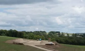 Un chantier de terrassement de bâtiment agricole au milieu de champs de maïs