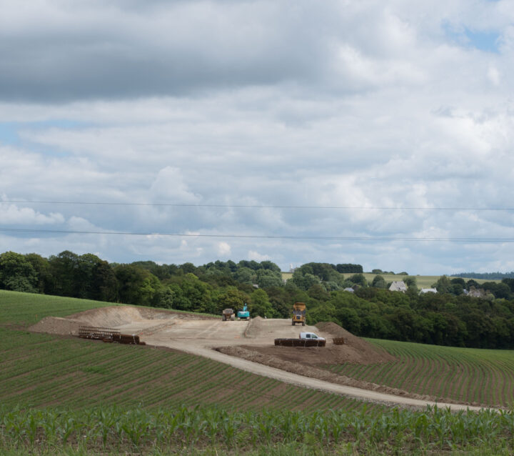 Un chantier de terrassement de bâtiment agricole au milieu de champs de maïs