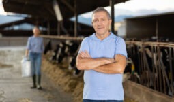 Un homme les bras croisés dans une stabulation