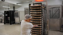 une femme qui tire un rack d'oeufs dans un couvoir