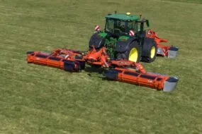 Un tracteur et un groupe de fauche à vis Kuhn dans un champ