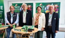 Les responsables du space derrière une table et devant les panneaux de l'affiche 2025